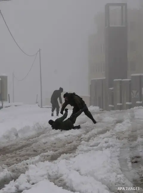 Palestinian security personnel engage in a snowball fight near their headquarters in the West Bank city of Hebron 10 January 2013. The higher elevations in the Palestinian Authority areas and Israel, including Jerusalem,...