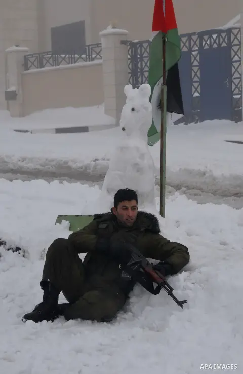 Palestinian security personnel engage in a snowball fight near their headquarters in the West Bank city of Hebron 10 January 2013. The higher elevations in the Palestinian Authority areas and Israel, including Jerusalem,...