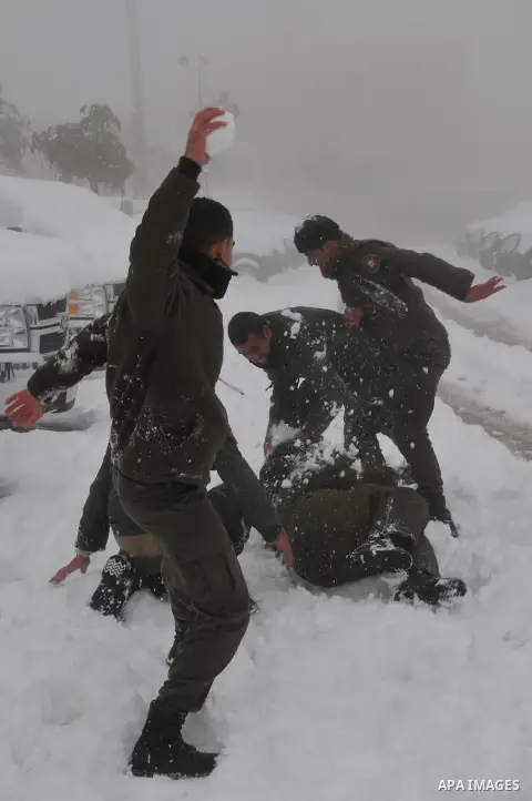 Palestinian security personnel engage in a snowball fight near their headquarters in the West Bank city of Hebron 10 January 2013. The higher elevations in the Palestinian Authority areas and Israel, including Jerusalem,...