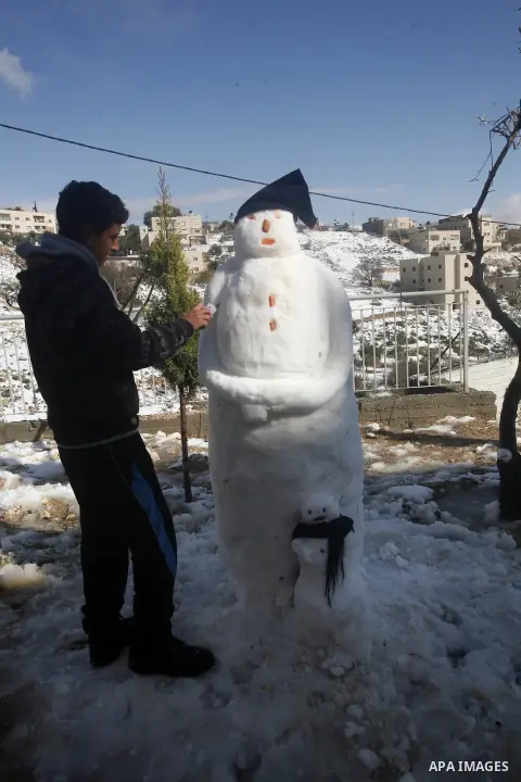 Palestinians walk at Al-Aqsa mosque compound as snow falls in the old city of Jerusalem on January 10, 2013. Jerusalem was transformed into a winter wonderland after heavy overnight snowfall turned the Holy City and much...