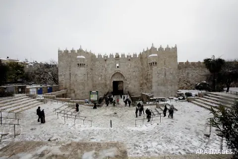 Palestinians walk at Al-Aqsa mosque compound as snow falls in the old city of Jerusalem on January 10, 2013. Jerusalem was transformed into a winter wonderland after heavy overnight snowfall turned the Holy City and much...