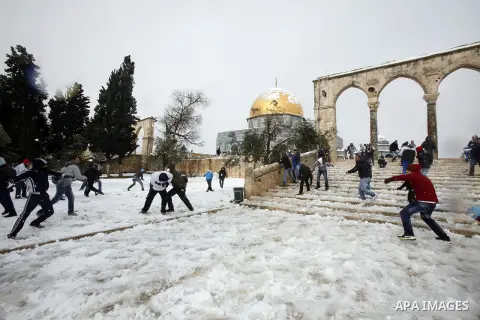 Palestinian children play with snow at the Al-Aqsa mosque compound in the old city of Jerusalem on January 10, 2013. Jerusalem was transformed into a winter wonderland after heavy overnight snowfall turned the Holy City...