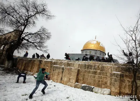 Palestinian children play with snow balls at the Al-Aqsa mosque compound in the old city of Jerusalem on January 10, 2013. Jerusalem was transformed into a winter wonderland after heavy overnight snowfall turned the Holy...