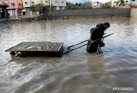 A Palestinian man tows a cart in a flooded street after a torrential rains in Rafah southern Gaza strip on 10 january 2013. In Gaza, cold weather and heavy rain flooded several of the tunnels running between the territor...