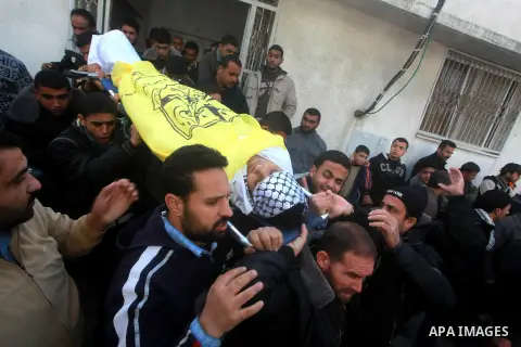 Palestinians mourners carry the body of Anwar Al-Mamlouk, 22, during his funeral in Gaza City on January 12, 2013. Israeli army gunfire killed Mamluk and wounded another man in the northern Gaza Strip, a spokesman for th...