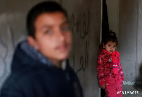 Palestinian children watch the funeral of Anwar Al-Mamlouk, 22, mourn during his funeral in Gaza City on January 12, 2013. Israeli army gunfire killed Mamluk and wounded another man in the northern Gaza Strip, a spokesma...