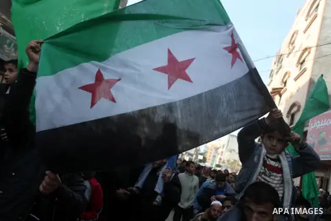 A Palestinian boy waves a Syrian opposition flag during a rally organized by Hamas movement in the northern Gaza Strip, in support of the Syrian revolution, January 18, 2013. Photo by Majdi Fathi