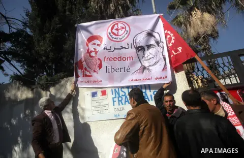 Palestinian supporters of the Popular Front for the Liberation of Palestine (PFLP) take part in a protest outside the French Cultural Center calling for the release of Lebanese militant Georges Ibrahim Abdallah (portrait...