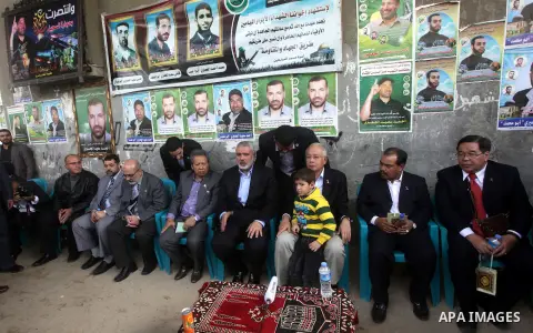 Malaysian Prime Minister Najib Razak, hugs the son of late Hamas military commander Ahmed Al-Jaabari, who was killed in an Israeli air strike on his car, as he sits next to senior Hamas leader Ismail Haniyeh, during his...