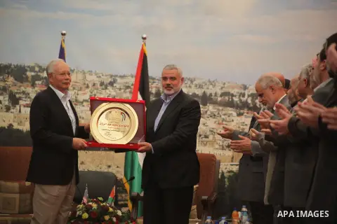 Palestinian Prime Minister Ismail Haniyeh, Malaysian Prime Minister Najib Razak, with a commemorative gift during their meeting in Gaza City , Jan. 22, 2013. During his first-ever visit to the territory, Najib Razak is m...