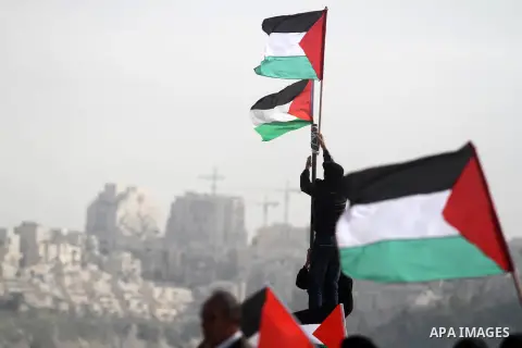 Palestinian activists fix a flag over confiscated lands by Israeli army on January 25, 2013 in the West Bank village of Beit Iksa. Activists said recently that the Israeli army would confiscate over 500 dunams (124 acres...