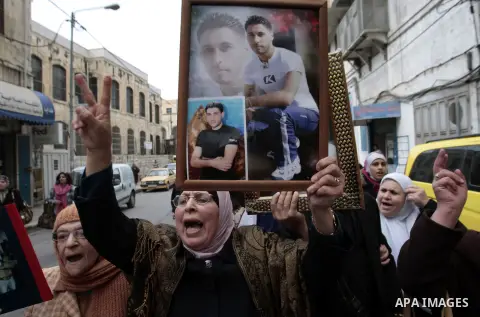 Palestinians take part in a protest calling for the release of Palestinian prisoners from Israeli jails in front of the Red cross office in the West Bank city of Hebron, Jan. 28, 2013. Photo by Nedal Eshtayah