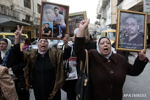 Palestinians take part in a protest calling for the release of Palestinian prisoners from Israeli jails in front of the Red cross office in the West Bank city of Hebron, Jan. 28, 2013. Photo by Nedal Eshtayah