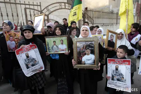 Palestinians take part in a protest calling for the release of Palestinian prisoners from Israeli jails in front of the Red cross office in the West Bank city of Hebron, Jan. 28, 2013. Photo by Nedal Eshtayah