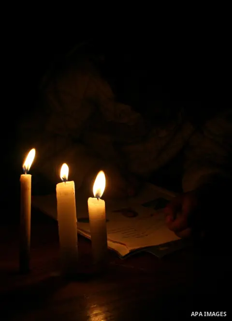 A Palestinian boy studies on the candles light during power outage in Gaza city on February 03, 2013. A Palestinian man died Saturday in northern Gaza after his house caught fire, two days after a family of six, includin...