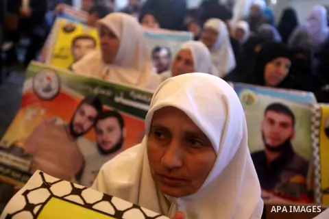 Palestinian women hold pictures of prisoners held in the Israeli jails during a protest calling for the release of Palestinian prisoners from Israeli jails in front of the Red cross office in Gaza city, Feb. 04, 2013. Ph...