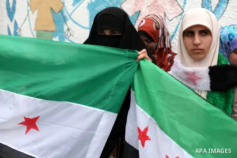 Palestinian women hold Syrian revolution flag during a demonstration in support of the Syrian people in front of U.N. headquarter office in Gaza city on February 5, 2013. Pressure mounted on Syrian President Bashar al-As...
