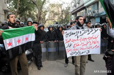 Protesters wave the pre-Baath Syrian flag, now used by the Free Syrian Army, as they shout slogans against the Syrian and Iranian regimes during a demonstration outside the Iranian embassy in the Egyptian capital Cairo o...