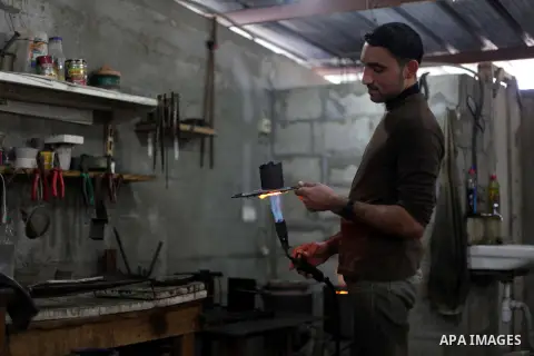 A Palestinian jeweller melts gold at his workshop in Gaza city on February 18, 2013. Photo by Ashraf Amra