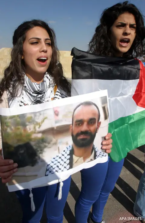 Palestinians carry placards and portraits of prisoners in Israeli jails during a protest in support of prisoners on hunger strike in Israeli prisons, in Jerusalem on February 20, 2013. Some 800 Palestinians serving time...