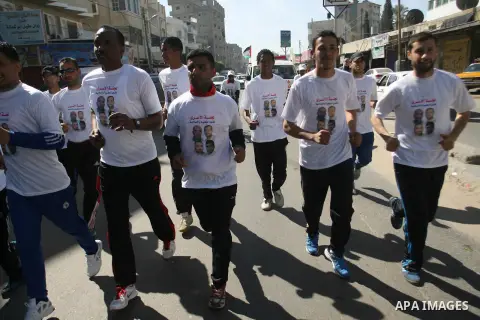 Palestinian youths participate in the run of Rafah to Gaza City during a solidarity with prisoners on hunger strike in Israeli prisons on February 21, 2013. Some 800 Palestinians serving time in Israeli jails were refusi...