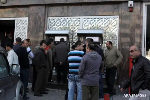 Palestinians queue to draw money from an automated teller machine of the Bank of Palestine in Gaza city on February 21, 2013. Photo by Ashraf Amra