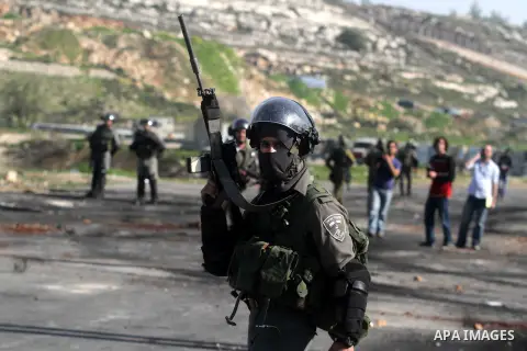 A masked Israeli soldier carries his M16 during clashes next to the Israeli military prison Ofer, south of the West bank city of Ramallah, 21 February 2013. Reports state that the protest is in support of Palestinian pri...