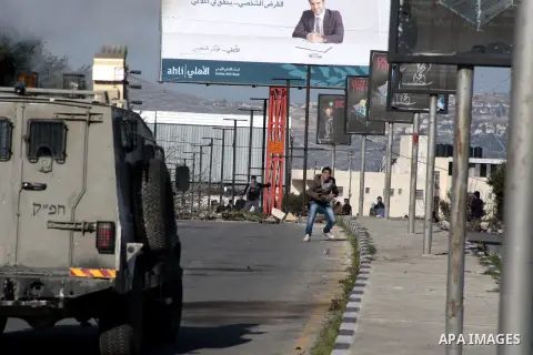 A Palestinian demonstrator throws stones at Israeli border police during clashes at Huwwara checkpoint near Nablus, the West Bank, 21 February 2013. According to Palestinian sources, 12 Palestinians were injured during t...