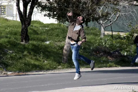 A Palestinian demonstrator throws stones at Israeli border police during clashes at Huwwara checkpoint near Nablus, the West Bank, 21 February 2013. According to Palestinian sources, 12 Palestinians were injured during t...