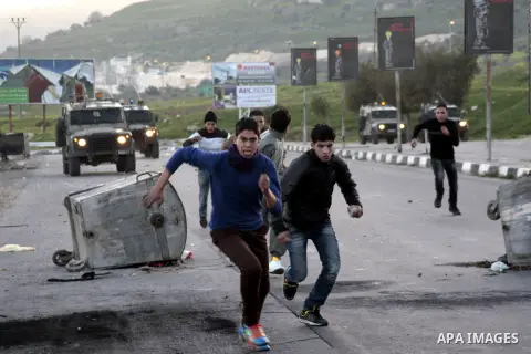 Palestinian demonstrators run to seek cover during clashes at Huwwara checkpoint near Nablus, the West Bank, 21 February 2013. According to Palestinian sources, 12 Palestinians were injured during the clashes,and five ar...