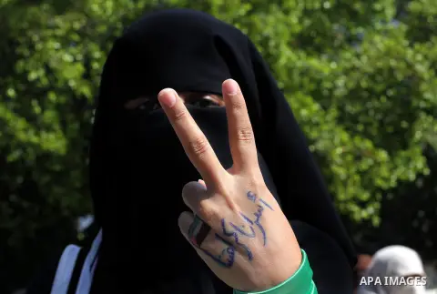 A Palestinian woman raises her hand written with the Arabic words "our prisoners are our dignity" as she takes part in a protest against the death of a Palestinian detainee in an Israeli jail, in Gaza City February 24, 2...