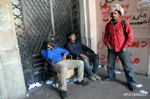 Egyptian protesters sit in front of Cairo's main administrative building on February 24, 2013, as they closed its doors part of a growing campaign of civil disobedience around the country. A group of protesters closed th...