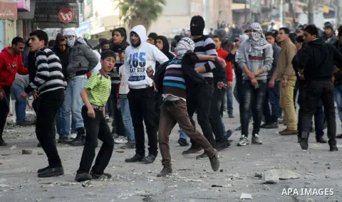 Palestinian protesters throw stones towards Israeli security forces during clashes in the West Bank city of Hebron, on February 24, 2013 following the death of a Palestinian prisoner held in Israel. Some 3,000 Palestinia...