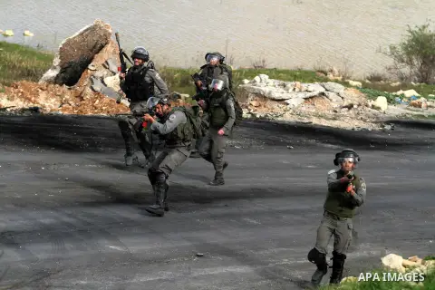An Israeli security officer rubbers towards Palestinian protesters during clashes next to the Israeli military prison 'Ofer' in Beitunya, south of the West Bank city of Ramallah, on February 24, 2013 following the death...