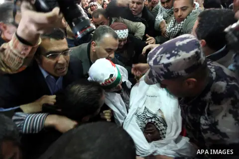 Palestinians mourn over the body of Arafat Jaradat mourn during his funeral in the West Bank village of Se'eer, near Hebron February 25, 2013. Jaradat's death in an Israeli jail on Saturday and a hunger strike by four ot...
