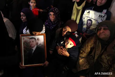 Palestinian relatives of Arafat Jaradat mourn during his funeral in the West Bank village of Se'eer, near Hebron February 25, 2013. Jaradat's death in an Israeli jail on Saturday and a hunger strike by four other Palesti...