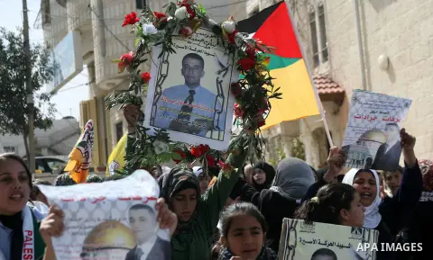 Palestinians carry portraits of Arafat Jaradat mourn during his funeral in the West Bank village of Se'eer, near Hebron February 25, 2013. Jaradat's death in an Israeli jail on Saturday and a hunger strike by four other...