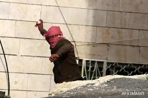 A Palestinian protester throws stones at Israeli border police during clashes in the village of Saair near the West Bank city of Hebron, on February 25, 2013. Palestinians attended the funeral of Arafat Jaradat, 30, whos...