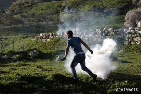 A Palestinian protester throws back a tear gas canister fired by Israeli security forces during clashes at Hawwara military checkpoint near the West Bank city of Nablus on February 26, 2013. Increased protests in the Wes...