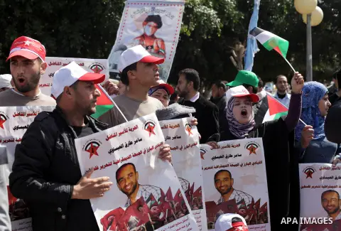 Demonstrators from the Palestinian factions take part in a protest against the death of a Palestinian detainee in an Israeli jail, in front of the Erez crossing into Israel near the northern Gaza Strip town of Beit Hanun...