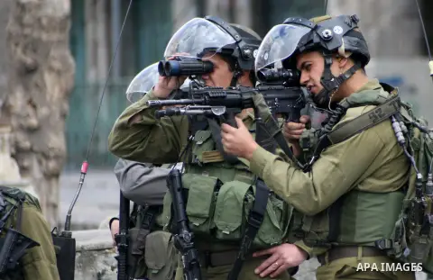 An Israeli soldier rubbers towards Palestinian demonstrators during clashes in the old city of Hebron on March 1, 2013 following a protest demanding the reopening of Shuhada Street, the one-time heart of the city, Flanke...