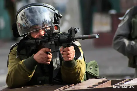 An Israeli soldier rubbers towards Palestinian demonstrators during clashes in the old city of Hebron on March 1, 2013 following a protest demanding the reopening of Shuhada Street, the one-time heart of the city, Flanke...