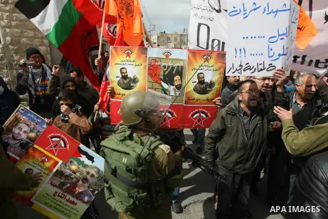 Palestinian demonstrators carry portraits of hunger striker prisoner Samer al-Issawi during a protest in the old city of Hebron on March 1, 2013 demanding the reopening of Shuhada Street, the one-time heart of the city,...
