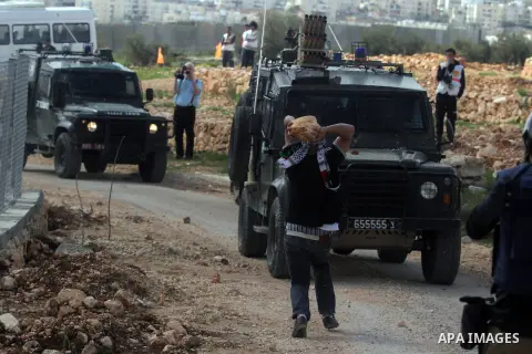 A Palestinian protester from the West Bank village of bilin throws stones towards Israeli troops during clashes next the Jewish settlement of Kereat Saifer, 01 March 2013. The residents of Bilin, west of Ramallah, marked...