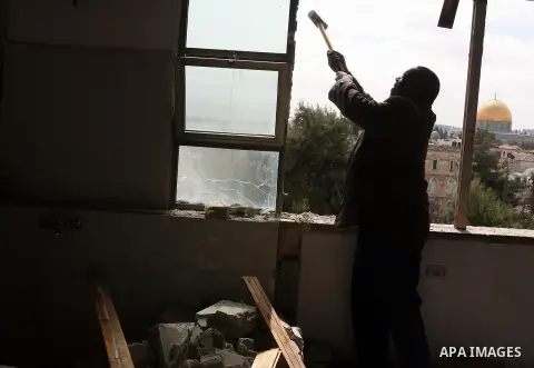 The golden Dome of the Rock is seen in the background as a Palestinian man from al-Said family, destroys his own home using a sledgehammer in Jerusalem's Old City on March 04, 2013. Al-Said decided to demolish his own ho...