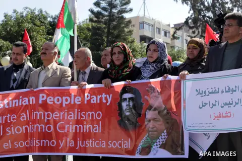 Palestinian factions hold portraits of late Venezuelan president Hugo Chavez during a rally in the Square of the unknown Soldier in Gaza city on march 07, 2013. Chavez died on 05 March from complications related to cance...