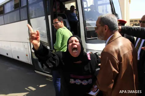 The mother of a victim in the case of last year's soccer violence in Port Said, holds a picture of her son, after scuffling with security officers who refused her entry to the Port Said Criminal Court, holding its hearin...