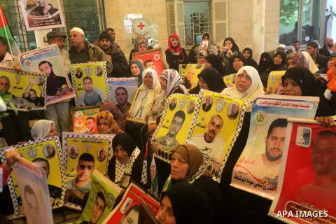 Palestinian women hold pictures of prisoners held in the Israeli jails during a protest calling for the release of Palestinian prisoners from Israeli jails in front of the Red cross office in Gaza city, on 11 march 2013....