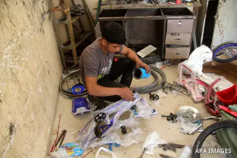 Khamis al-Burdini, 15, a Palestinian youth repairs bicycles at his workshop in Gaza city, on March 13, 2013. al-Burdini opened his workshop 3 years ago after leaving his school to provide his poor family . Photo by Ezz a...