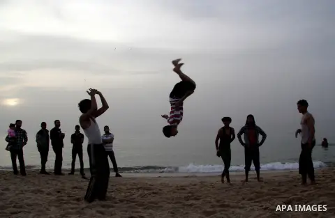 Palestinian children enjoy playing in the sea at Gaza beach during hot weather in Gaza city, March 15, 2013. The temperature of the Gaza strip reaches more than 30 degrees Celsius, Gazans escape to the beach and out from...